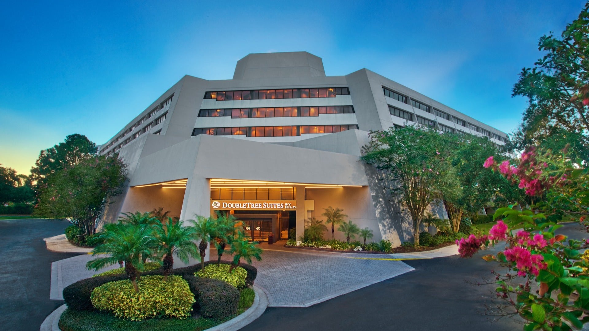 hotel exterior with trees and flowers