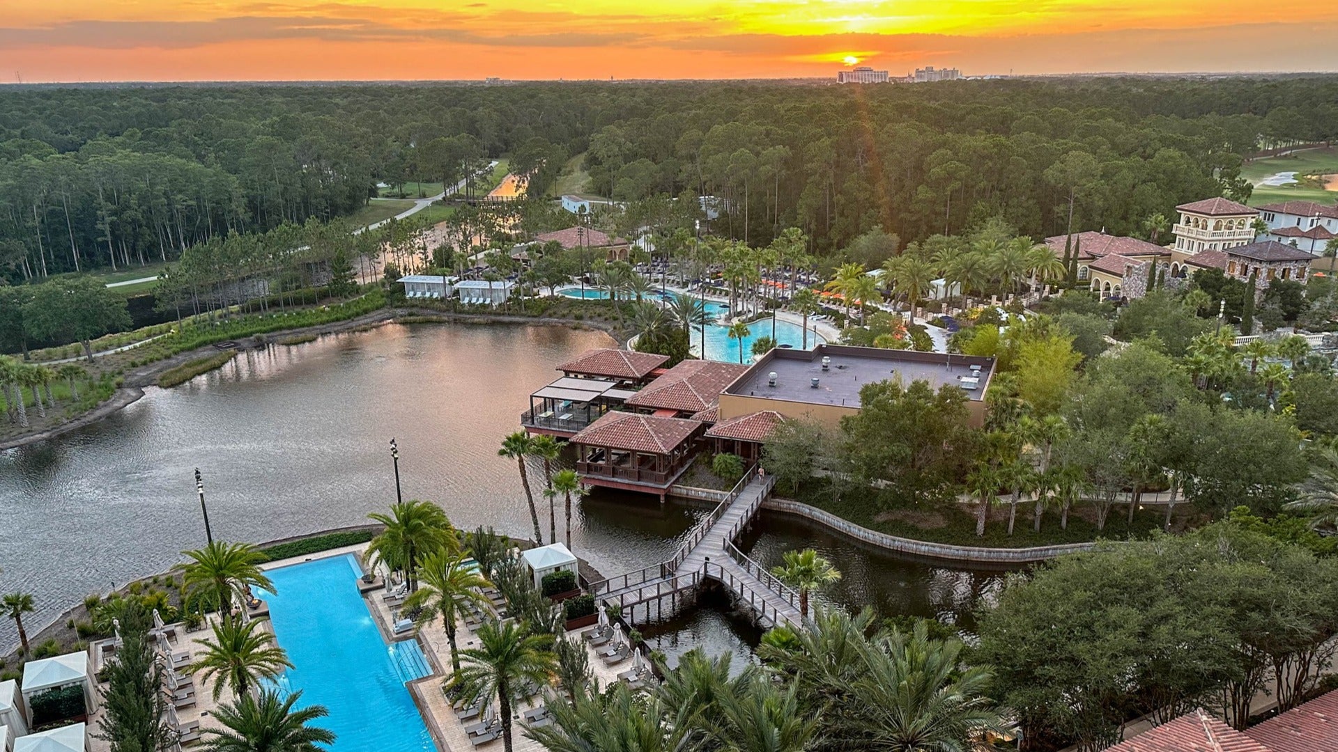 view of a hotel in disney world, trees and lake on the horizon