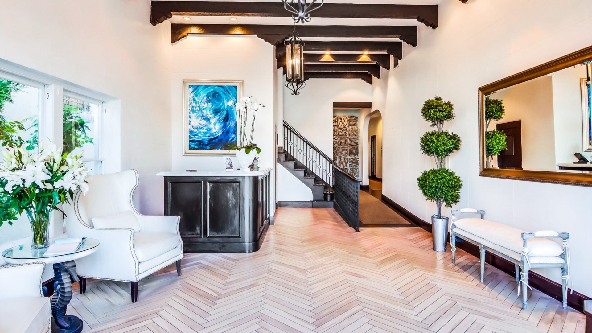 hotel room lobby with reception, stairs, seating area, mirror and lamps