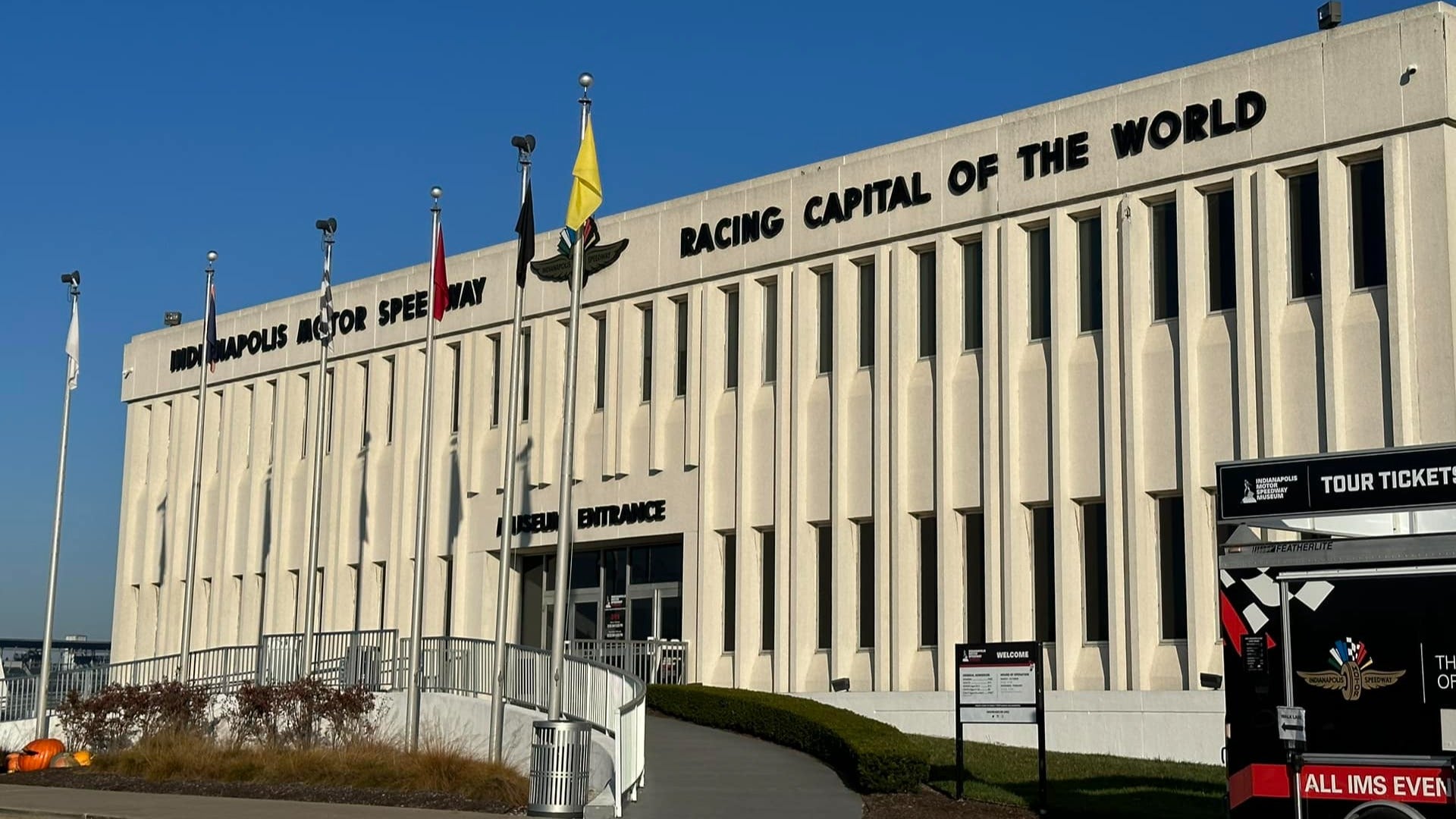 museum exterior with flags in front and ticket selling booth at the side