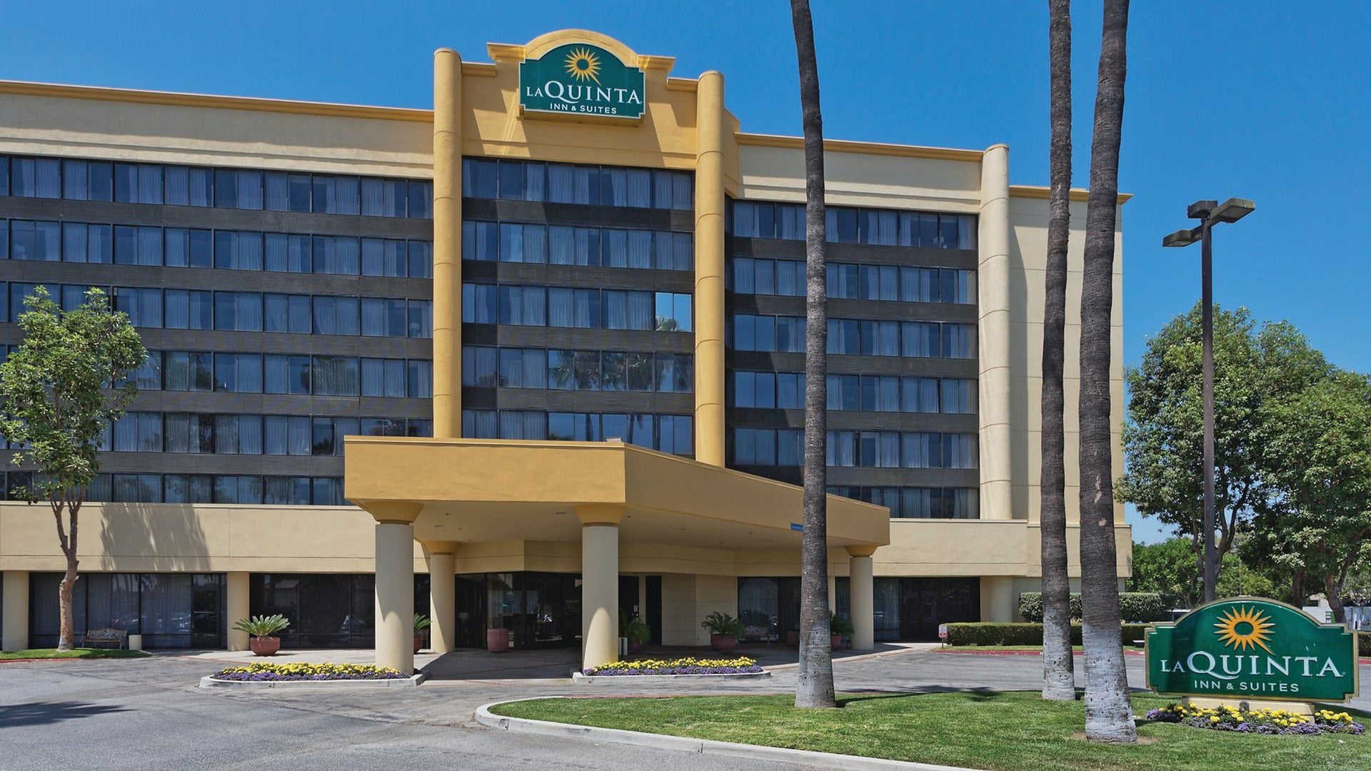 hotel exterior with trees in front and a driveway