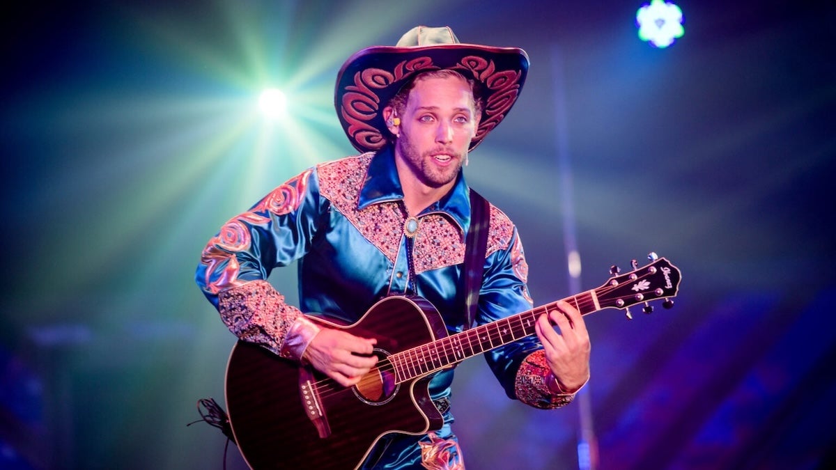 a man wearing a Mexican outfit and playing a guitar