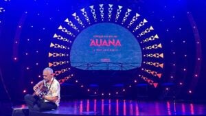 a man with his guitar sitting on stage