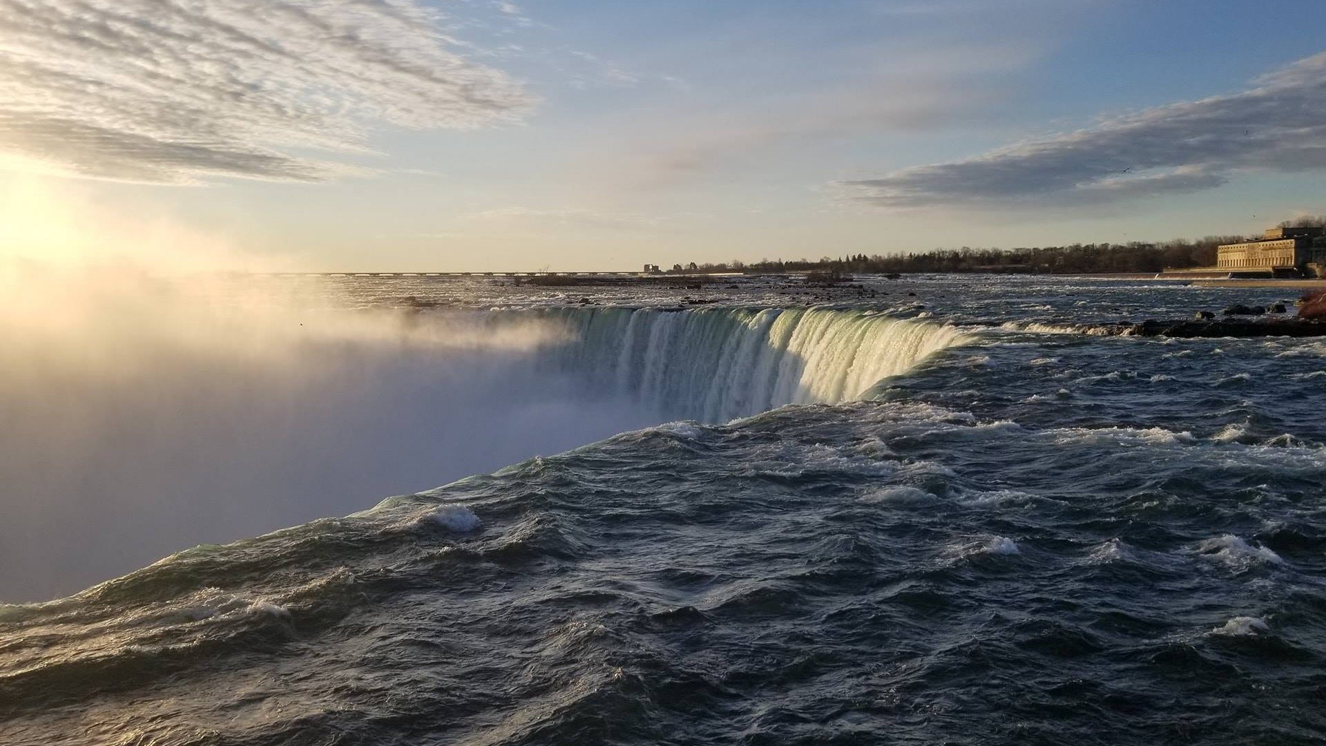 majestic view of waterfalls with a building at the back