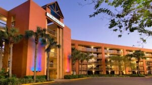 hotel exterior showing palm trees, rooms with balconies