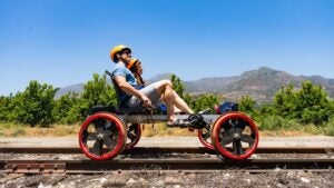 two people on a railbike with a view of mountains at the back