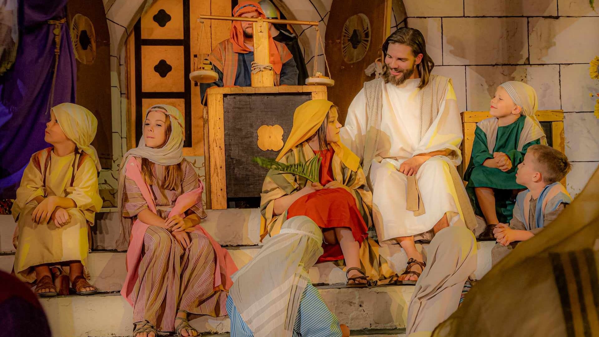 people in play portraying jesus christ with some children