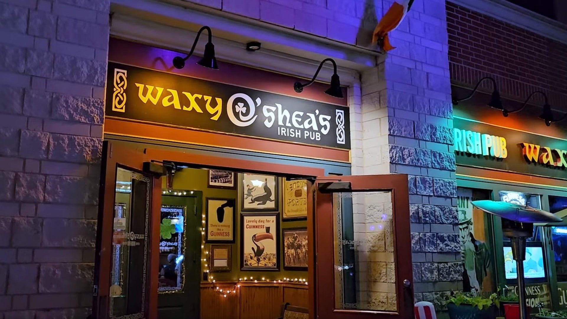 exterior of an irish pub, posters on the wall, string lights