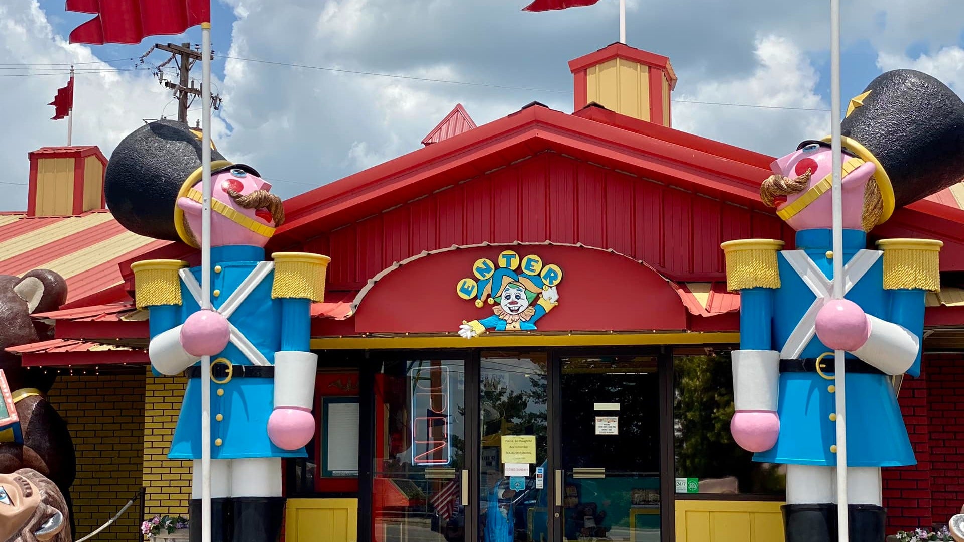 exterior of a toy museum with two guards in front and flags