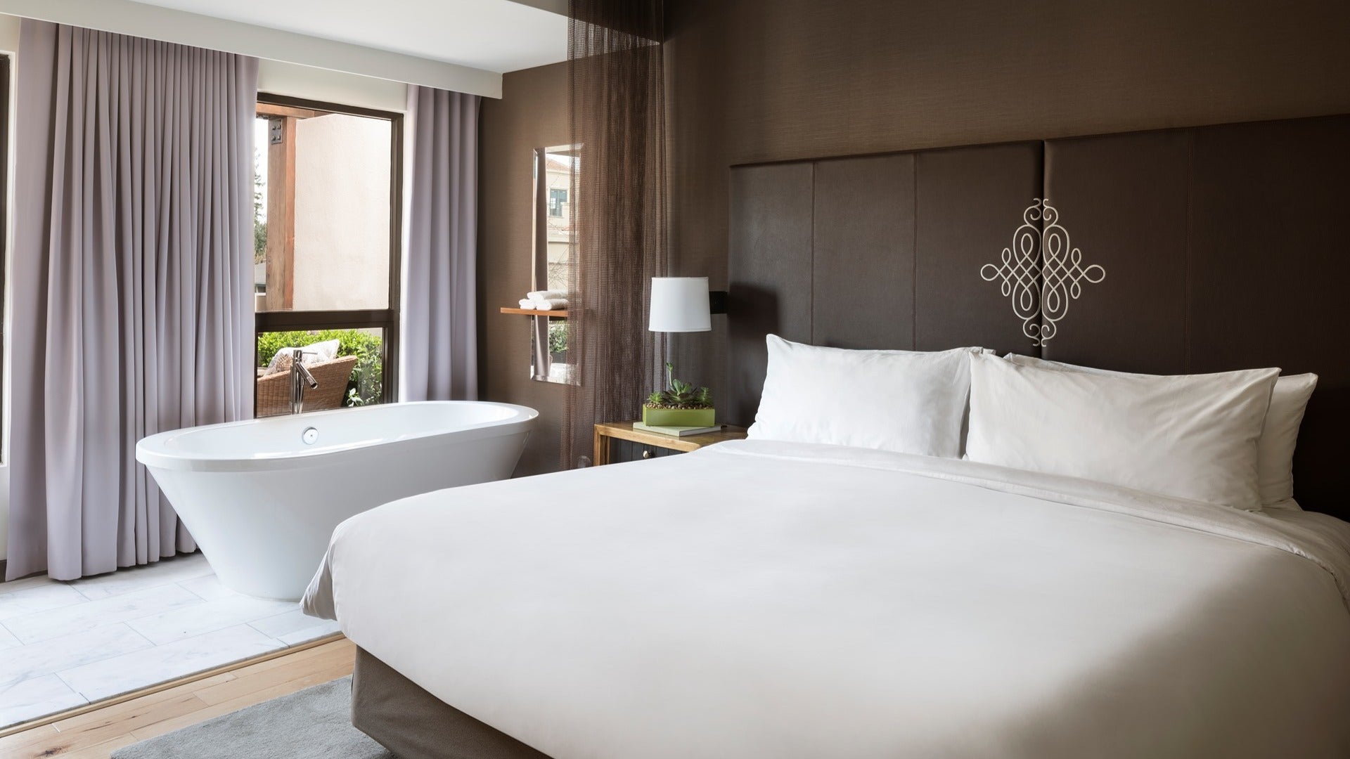 hotel bed with bathtub and windows