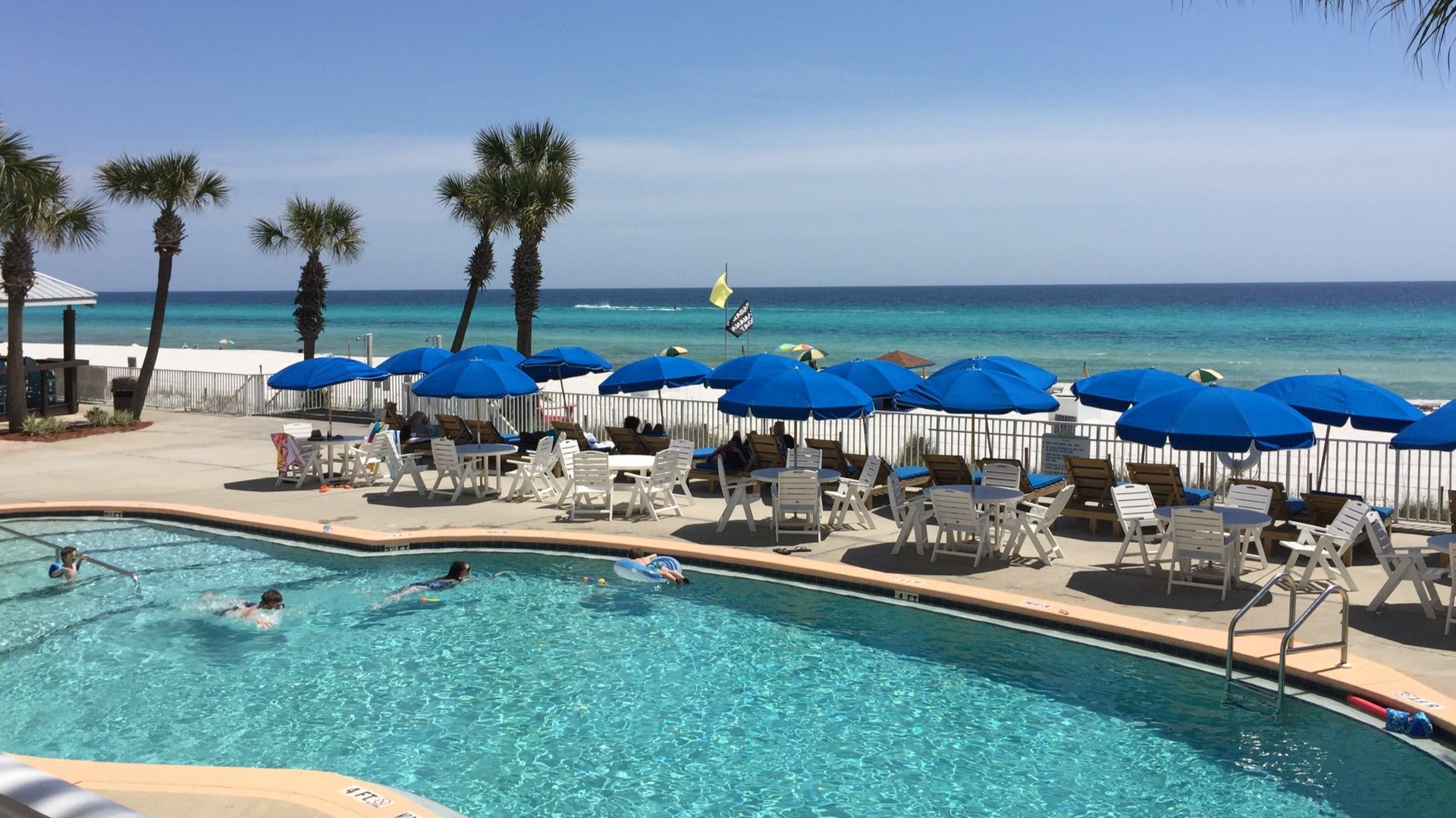 pool umbrellas and tables and chairs with a view of the ocean