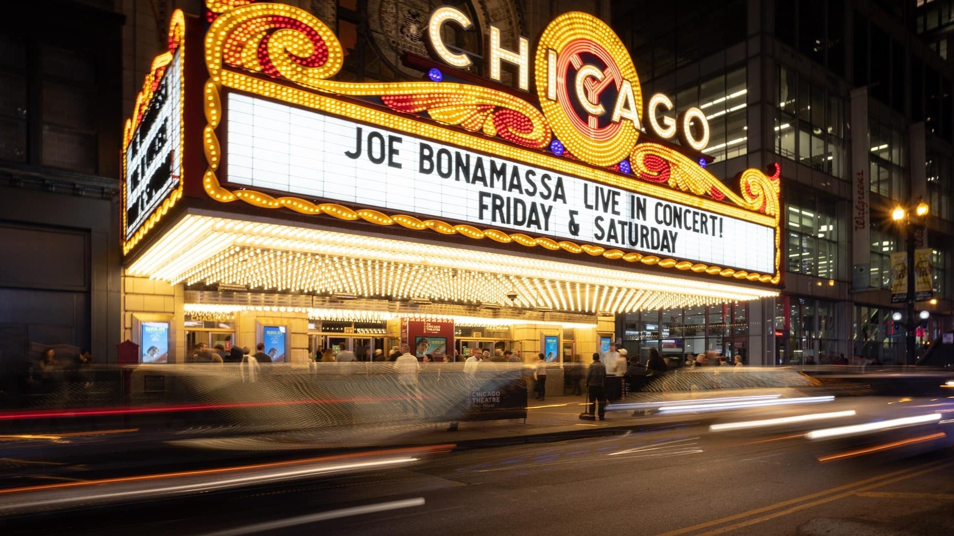 theater sign with lights and people along the street