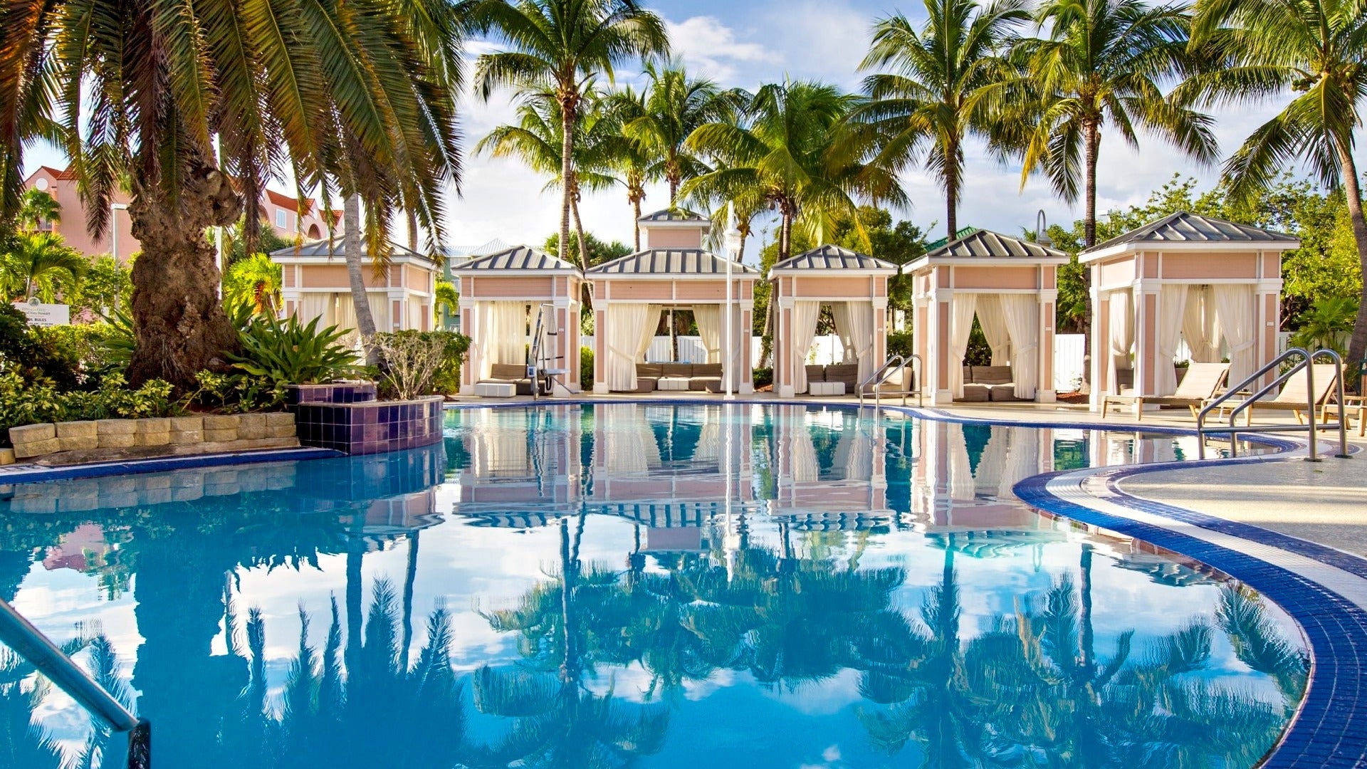 pool with pool cabanas and trees at the back