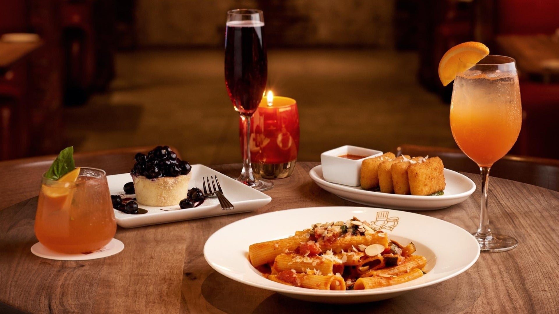 pasta dish and dessert with drinks on a table