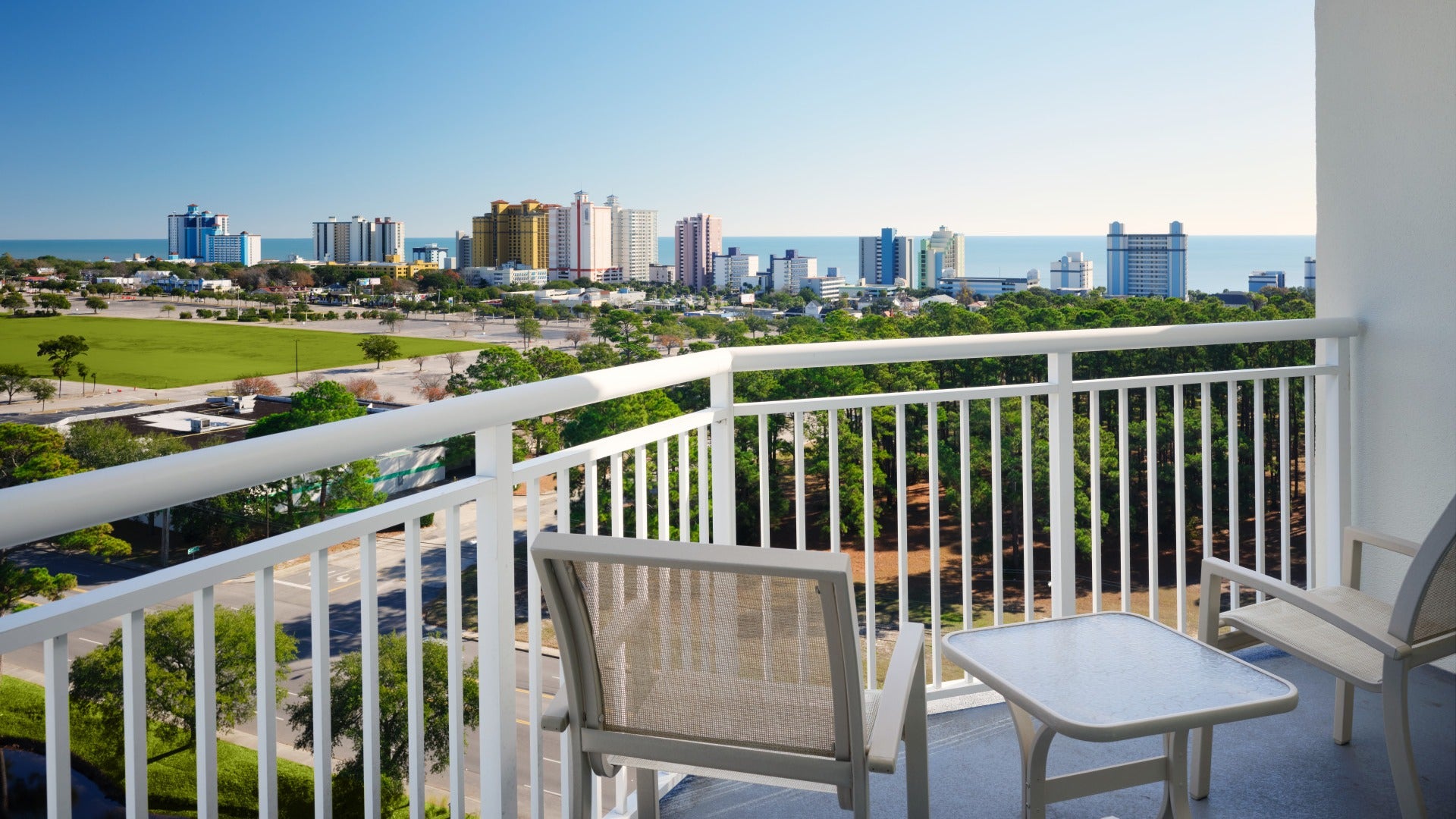 balcony with chairs overlooking the city and ocean