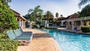 hotel and resort with pool, chairs, trees