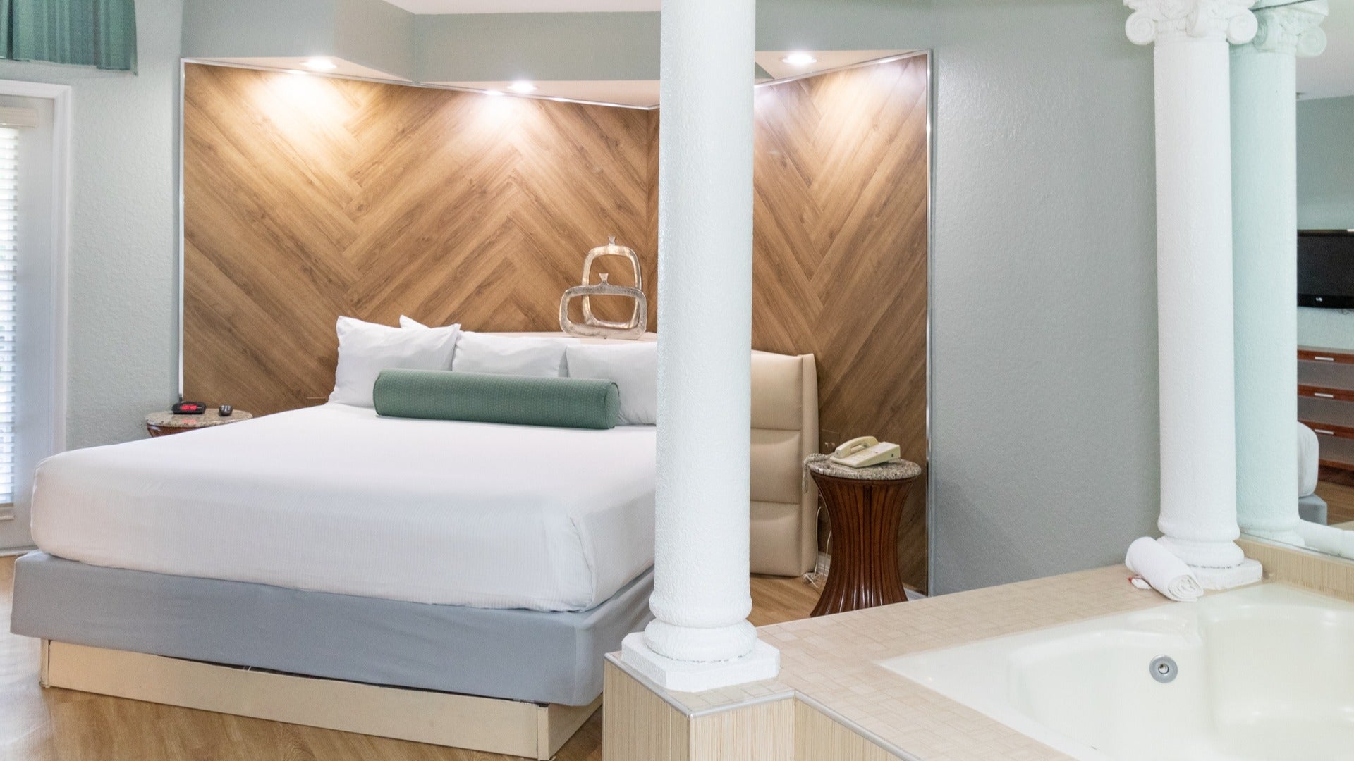 hotel bedroom with bed and tub and windows