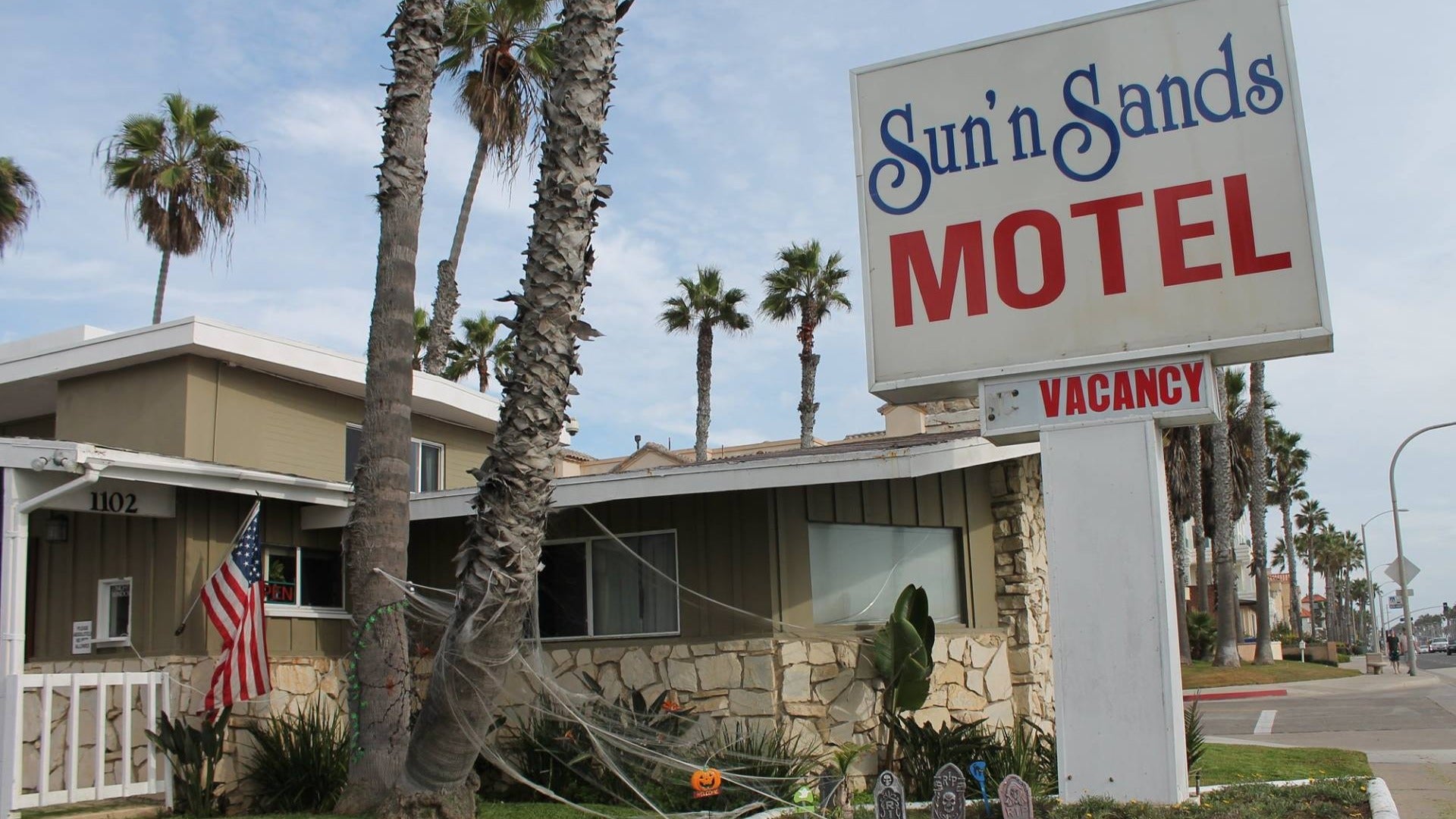 motel exterior with huge signage and american flag