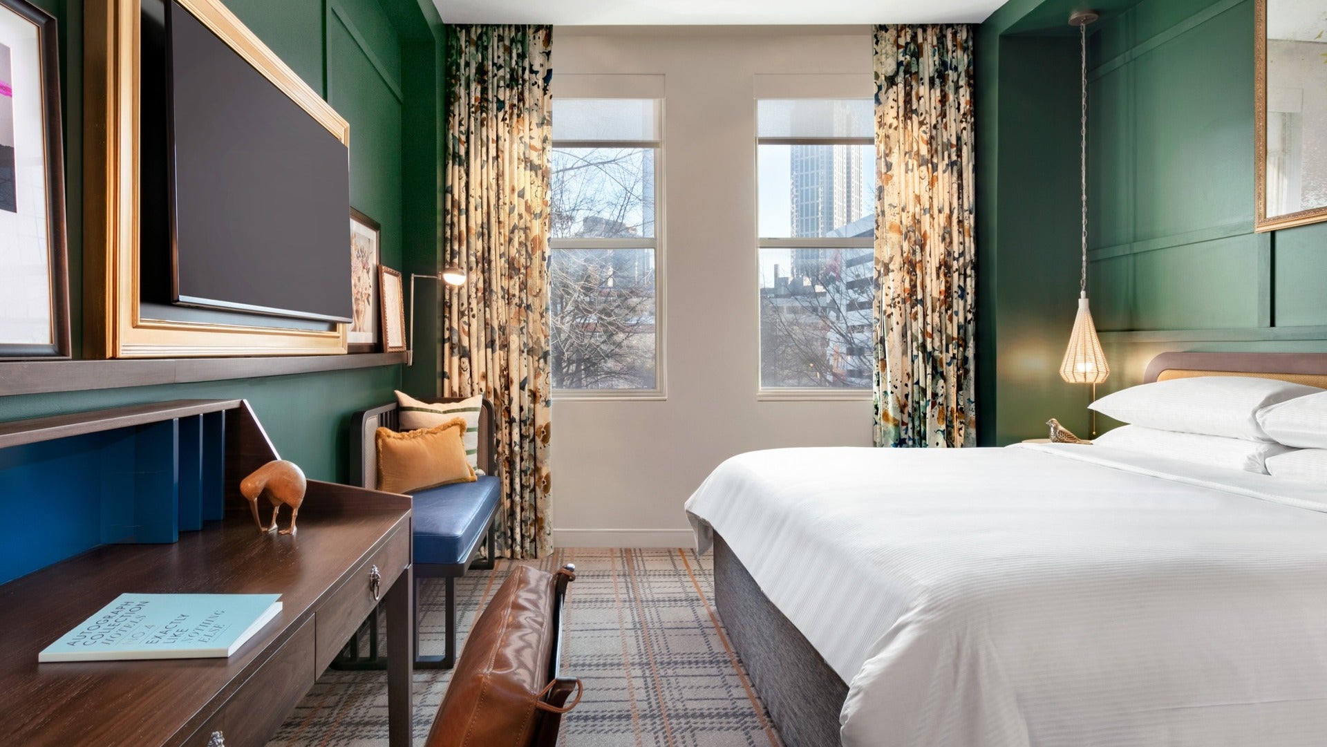 hotel room interior with bed, seat, windows, tv and lamps