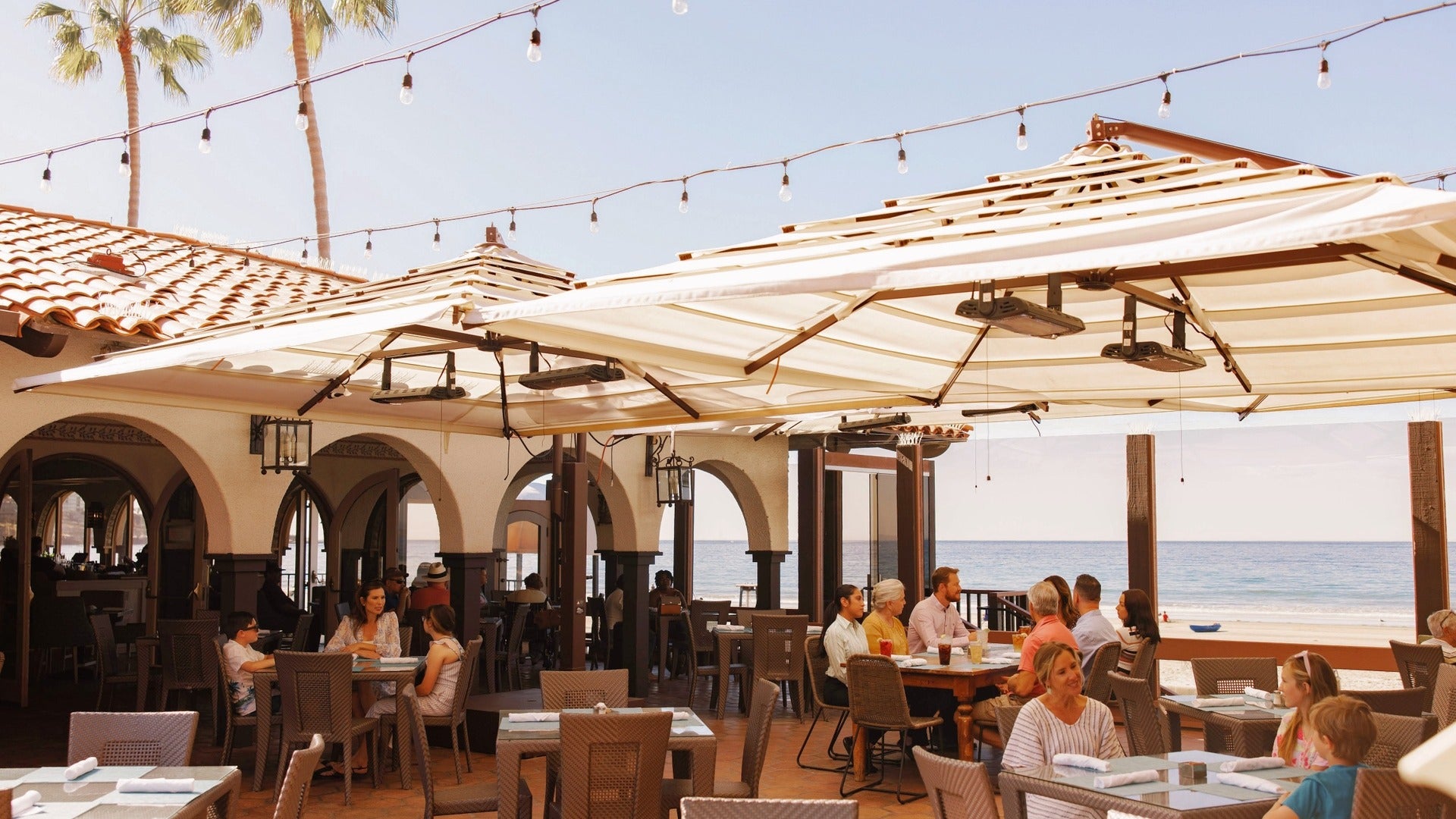 people dining at a restaurant with ocean background