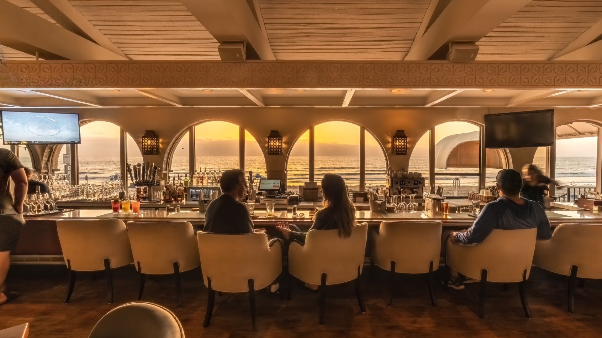 people dining at bar with view of the ocean