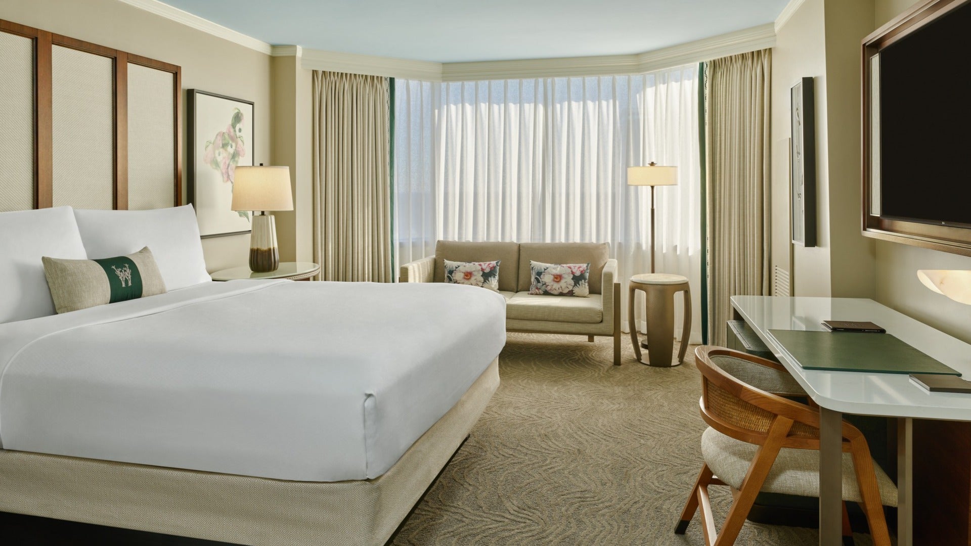 hotel room interior with bed, couch, working area, lamps and curtains