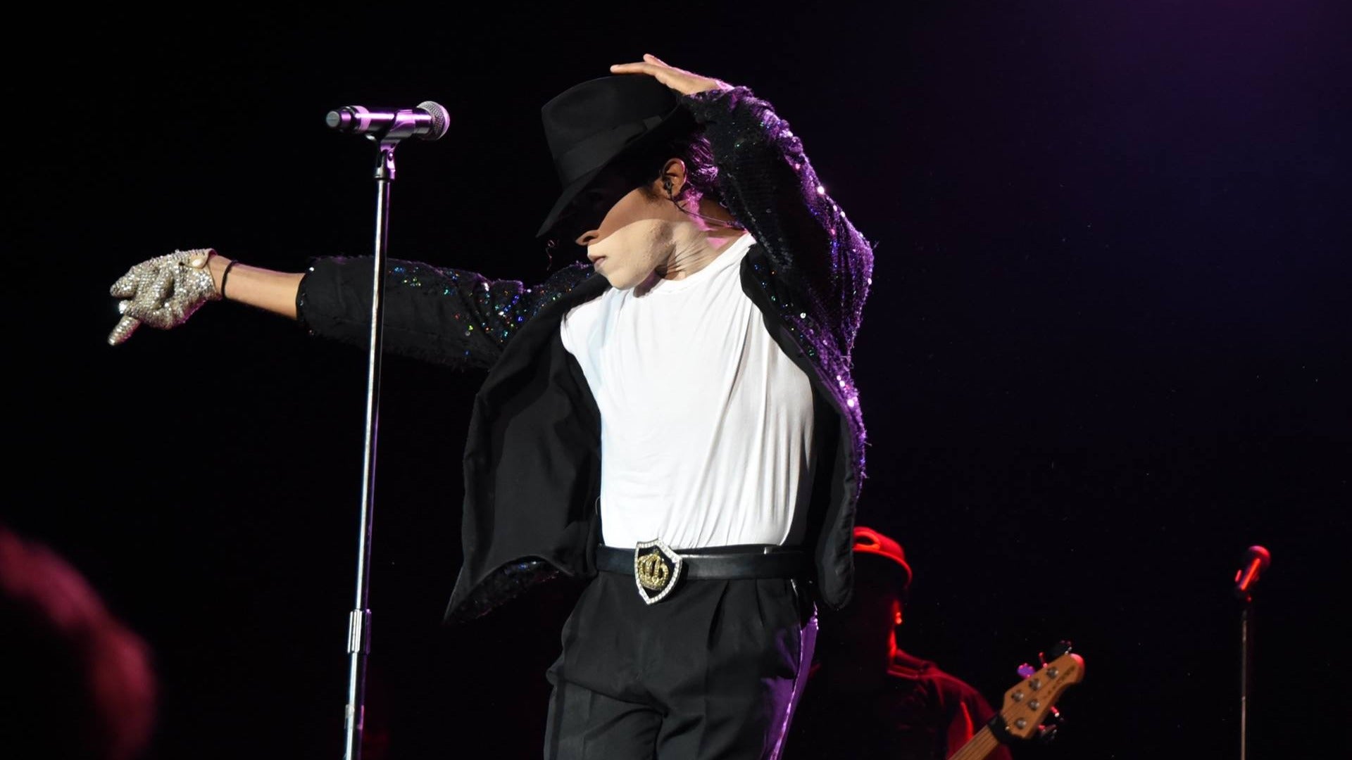 performer on stage with a band behind him