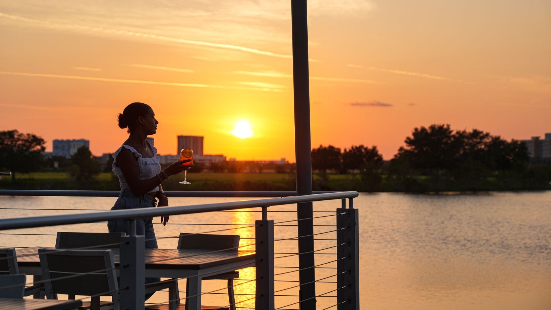 woman sipping on a drink overlooking lake eola