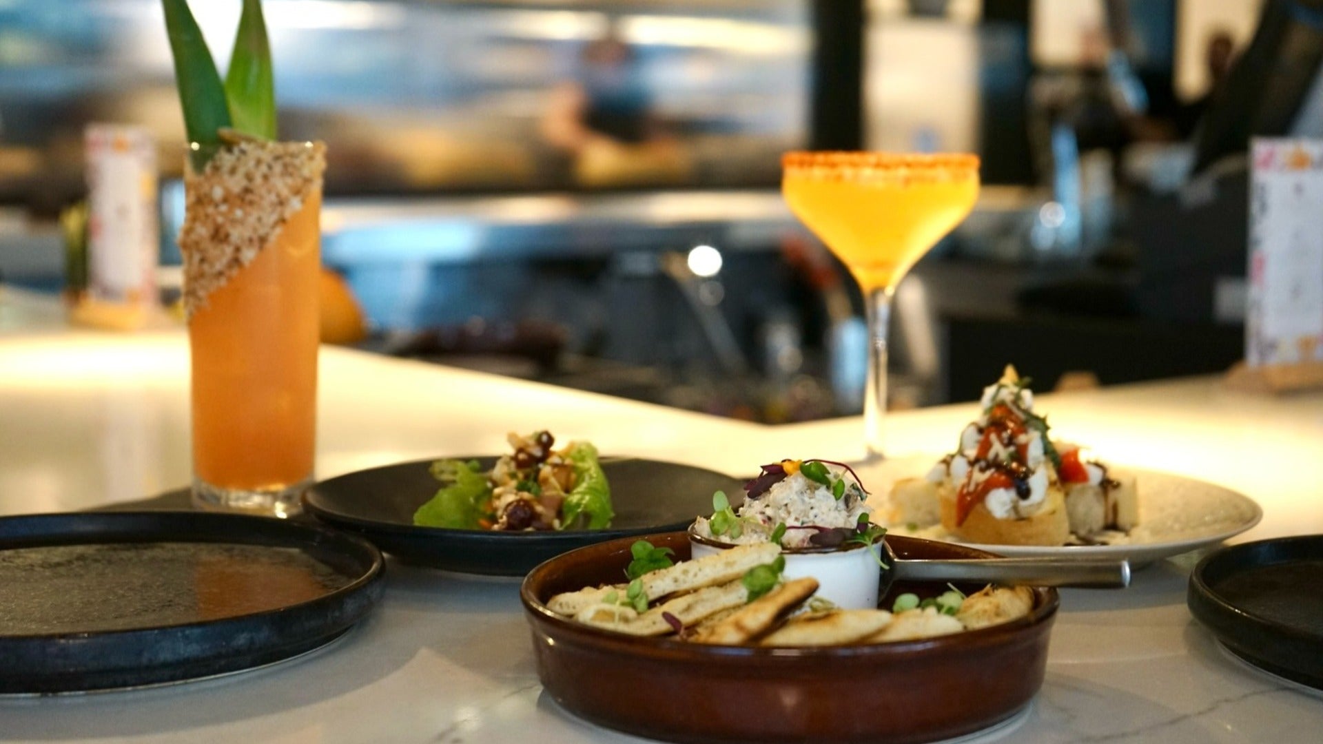 dishes served on a plate with drinks at the back