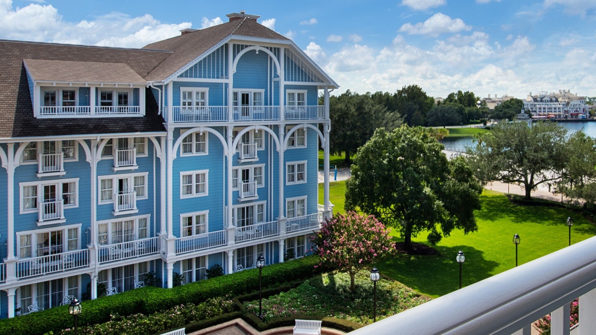 hotel with trees in front and a lake at the side