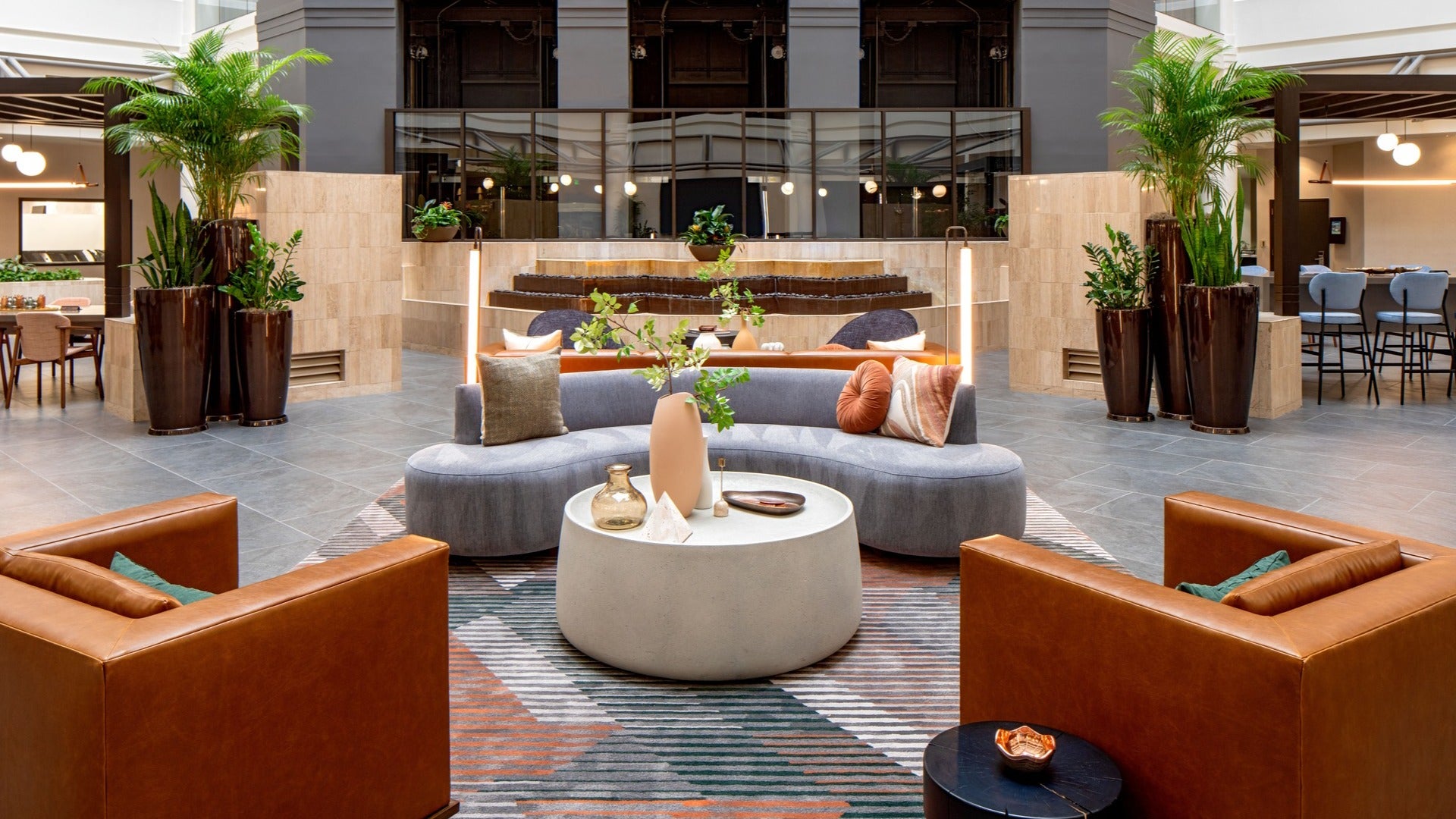 hotel lobby with couches, chairs, lights, and plants