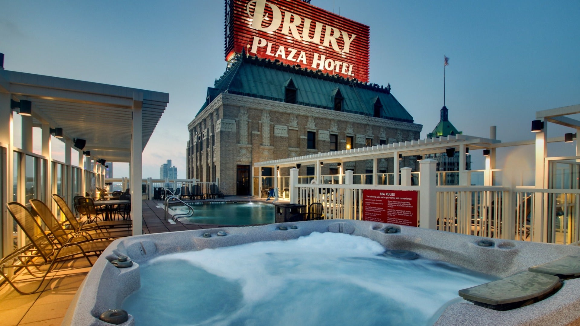 hotel signage, jacuzzi on rooftop with pool chairs on the side