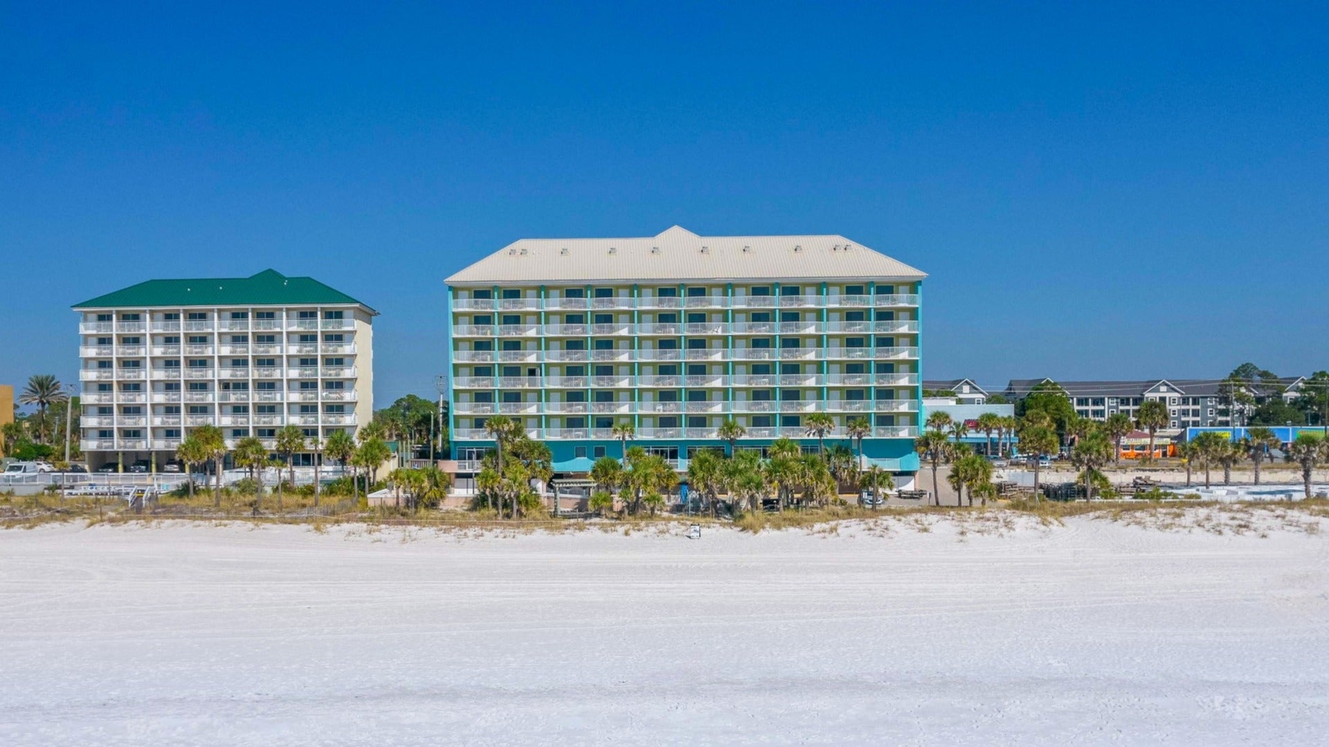 hotel in front of the beach with palm trees