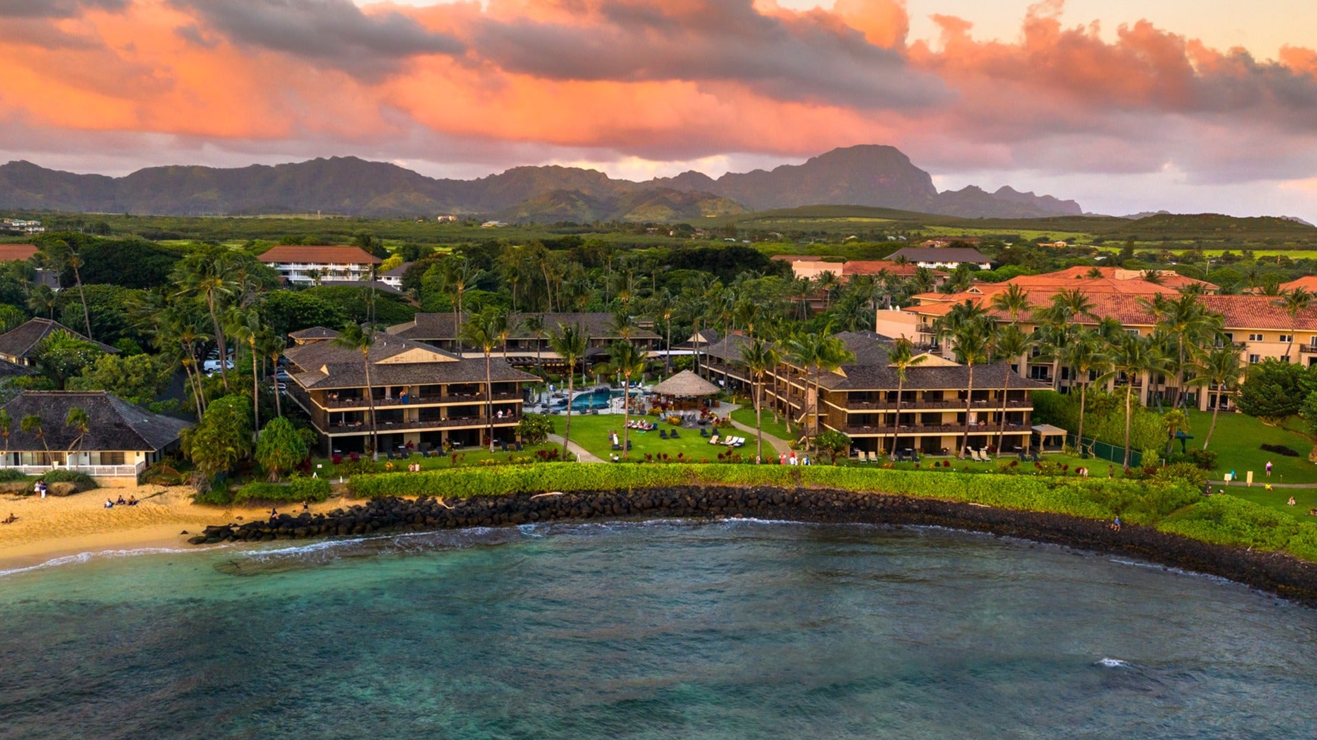 hotel surrounded by trees with a beach in front and the ocean