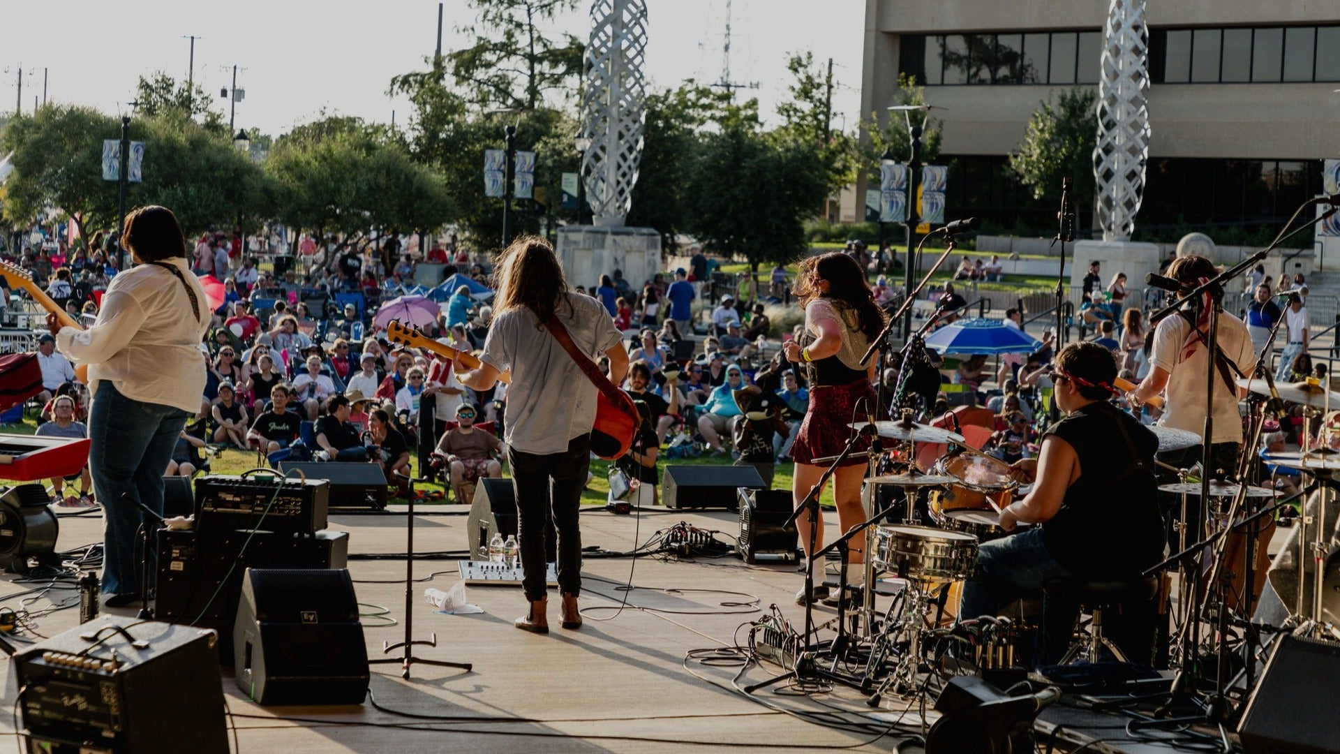 group of performers on stage with a crowd watching