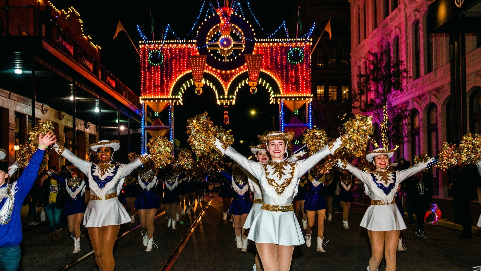 women in cheerleader outfits parading at mardi gras