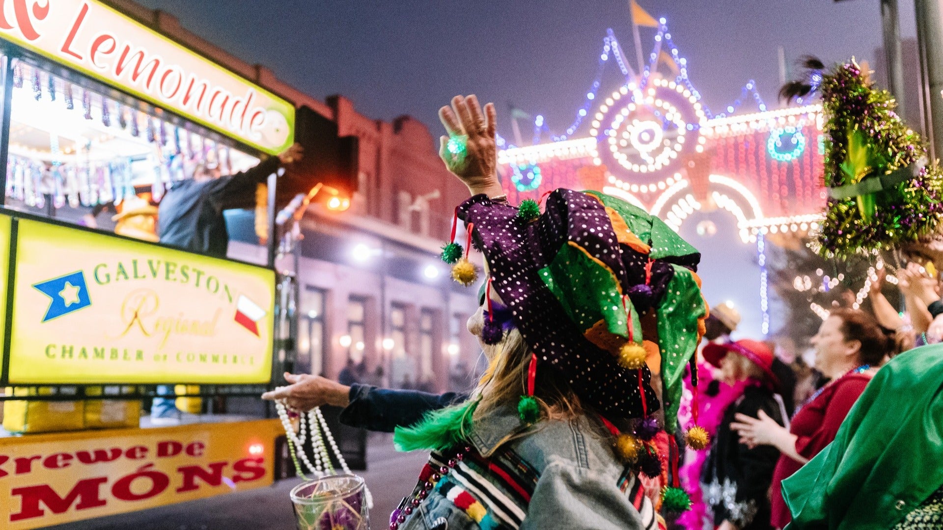 people throwing beads at a mardi gras celebration