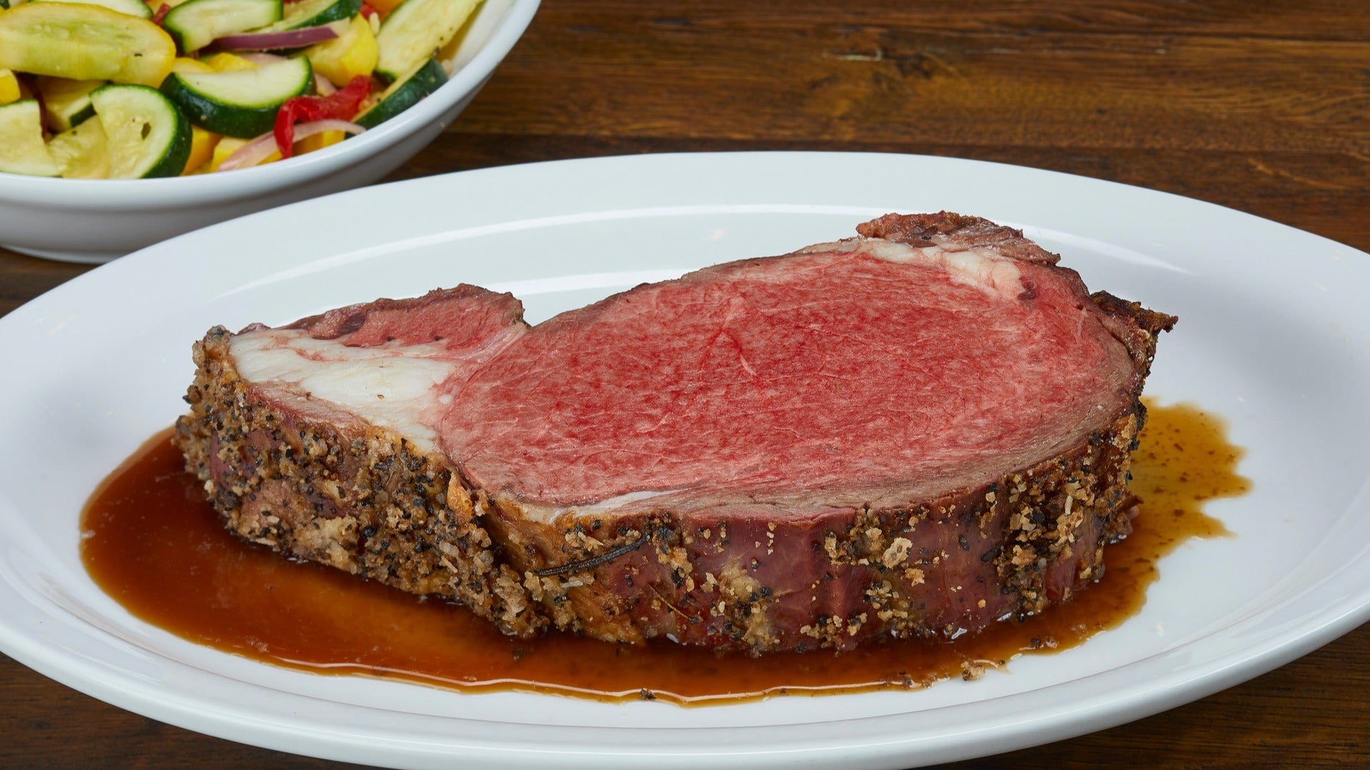 prime rib served with a side dish of salad