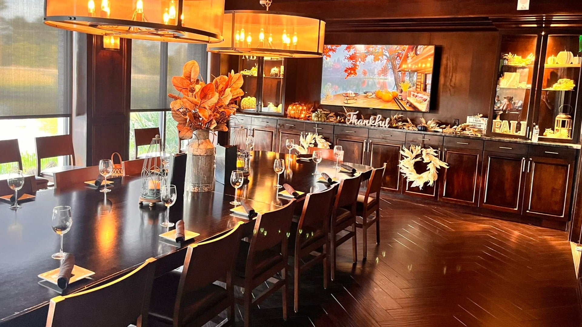 dining table with chairs and wine glasses, counter and decorations at the back