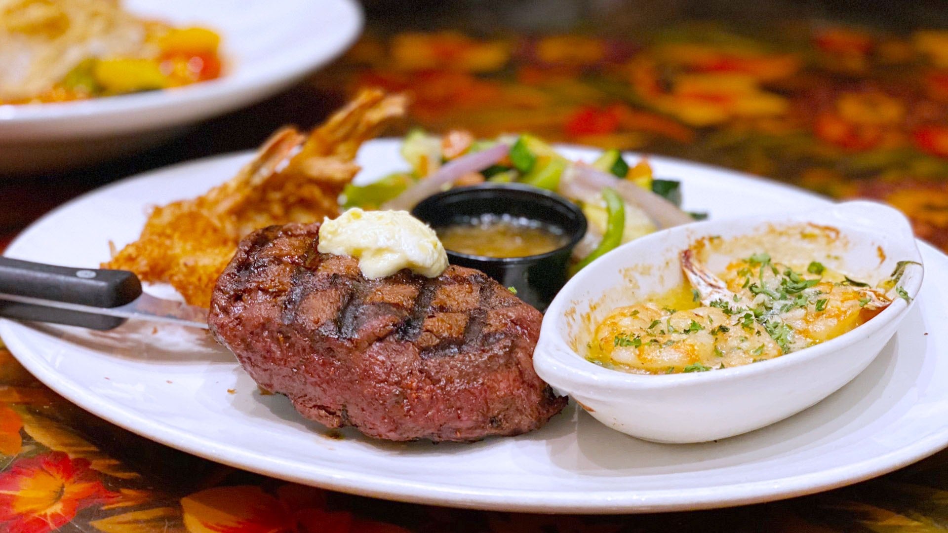 steak with sides of veggies and shrimp on a plate