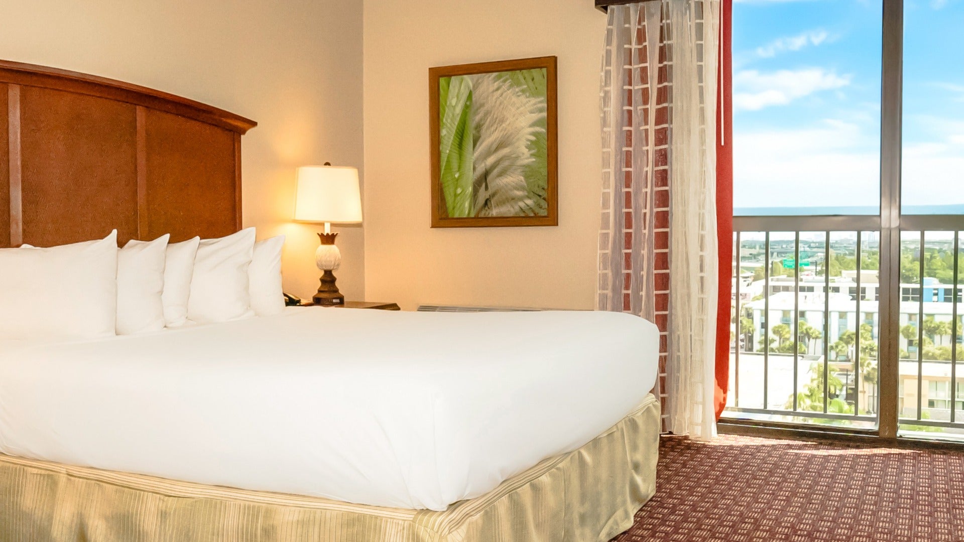 hotel room with a lamp, bed, and balcony