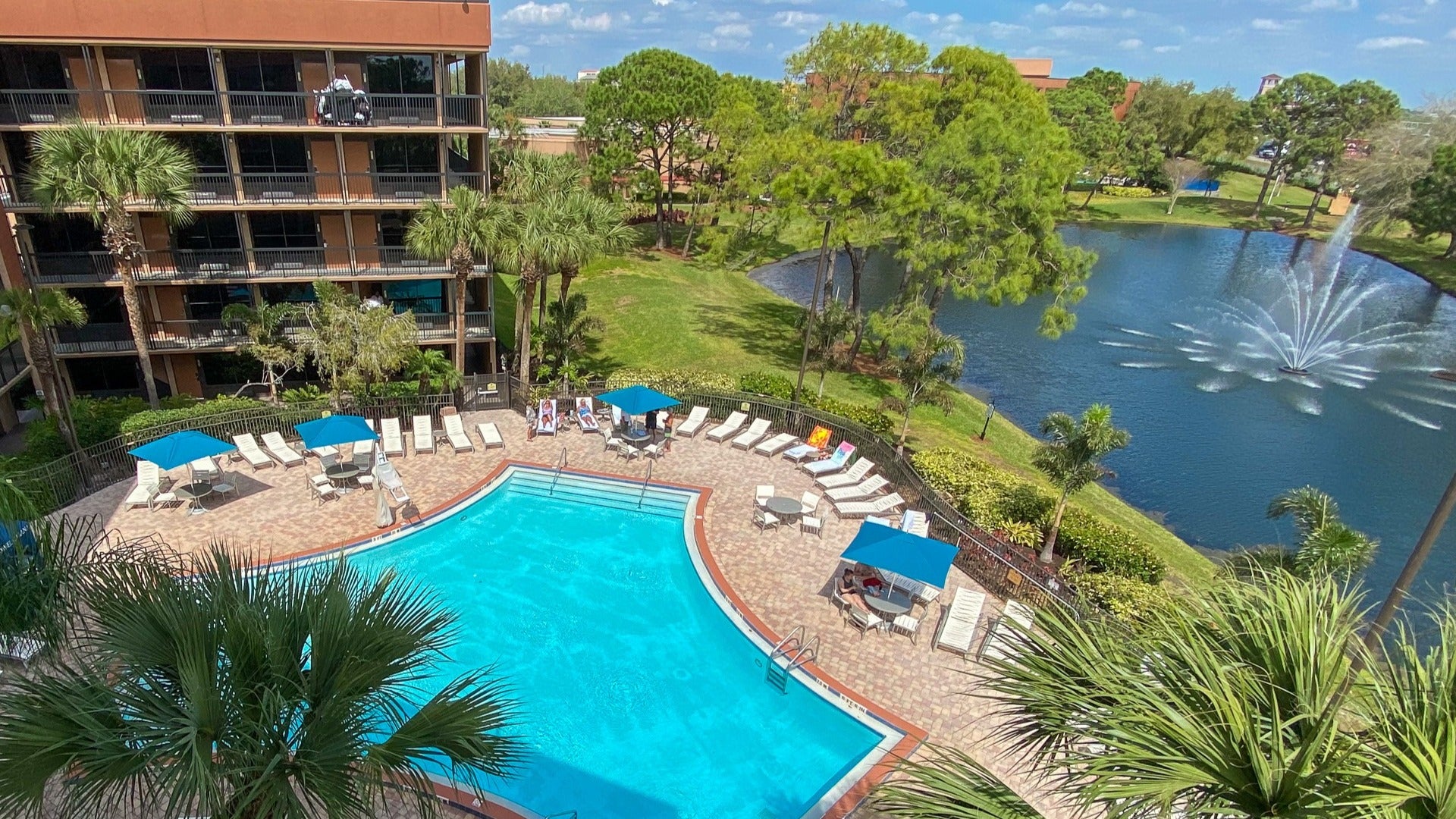 hotel with pool and gold course with fountain beside it