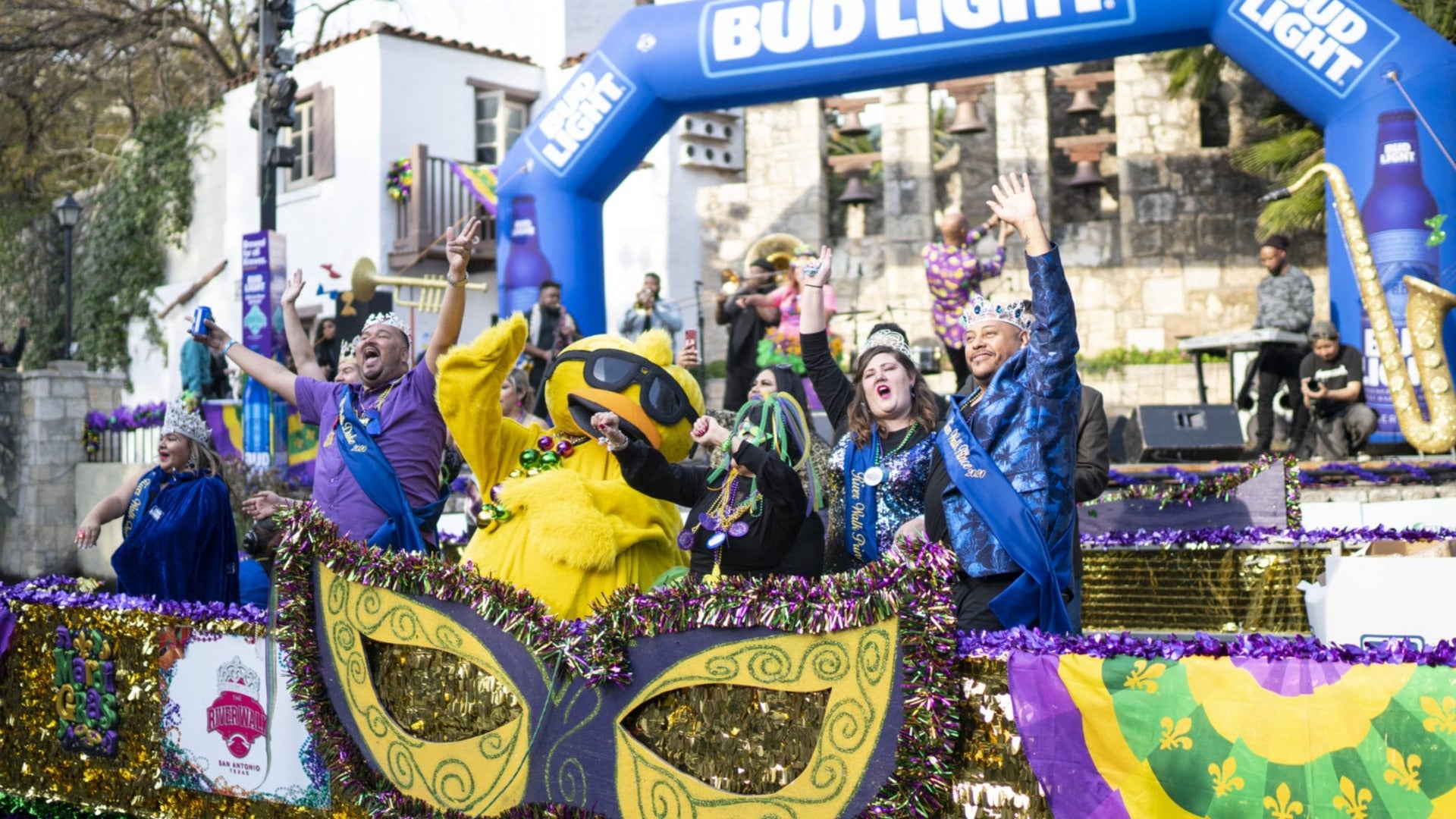 river parade float with people in mardi gras costumes on board