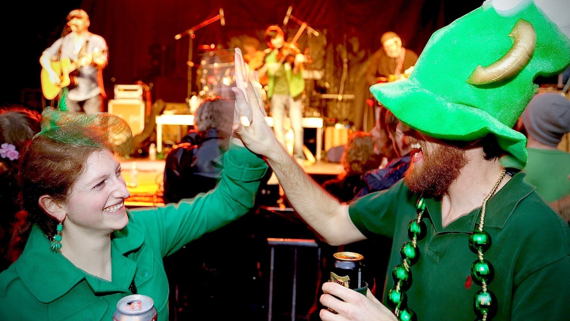 two people giving a high five with a band performing at the back