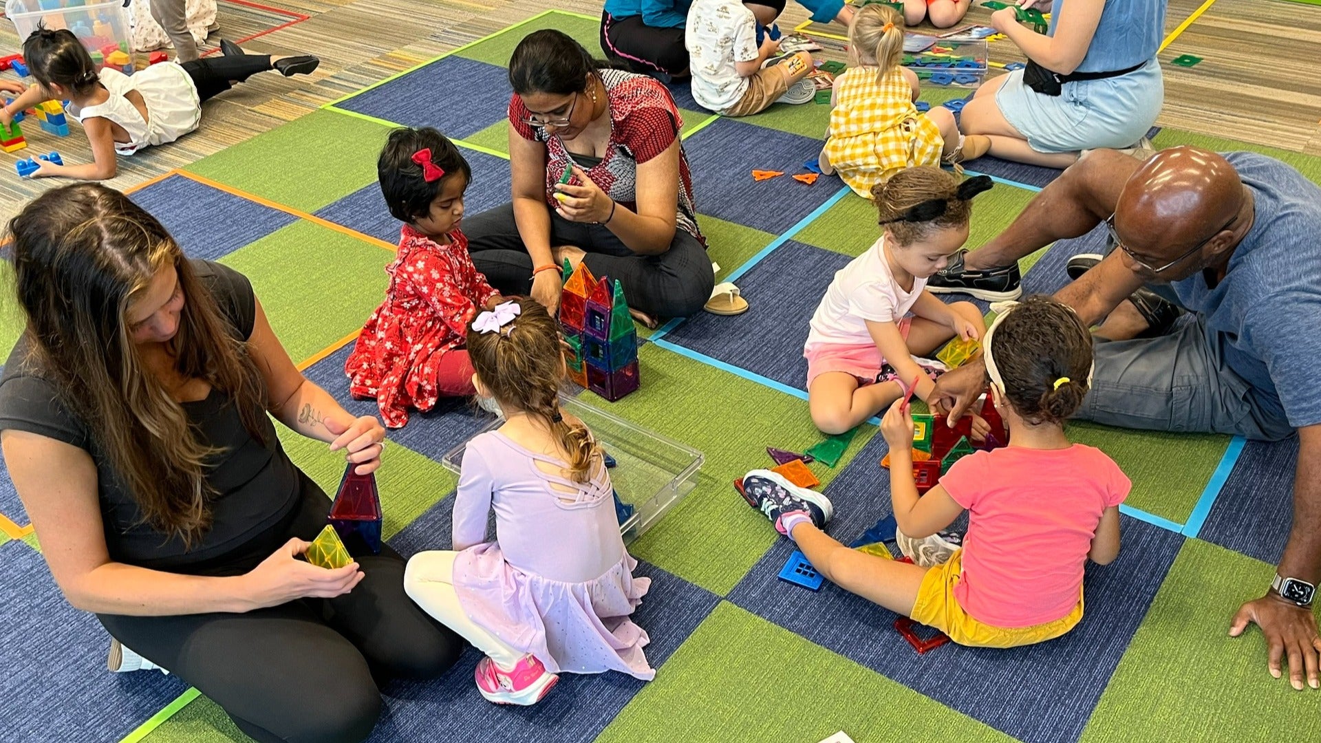 parents and children playing on a library floor