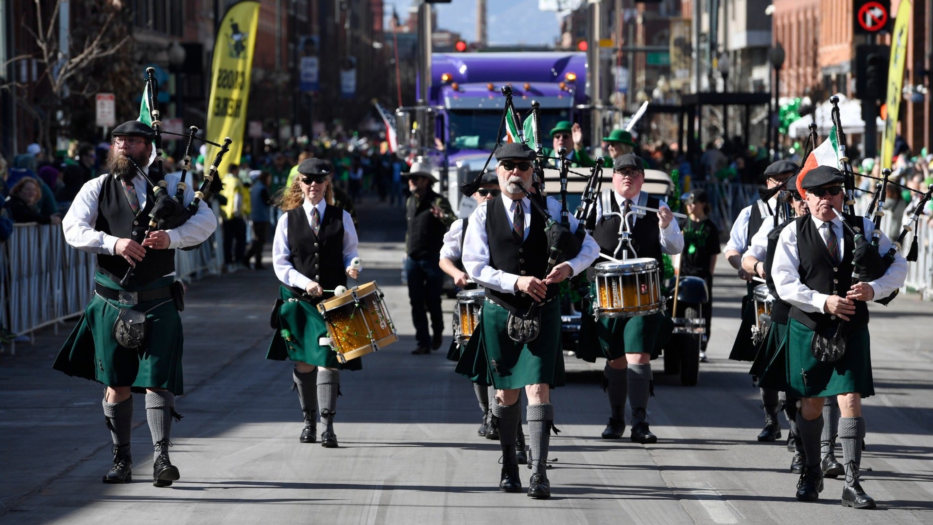 group of men in irish wear with bagpipes walking a parade during st patricks day