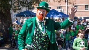 man dressed up for st patrick's day with a crowd behind him