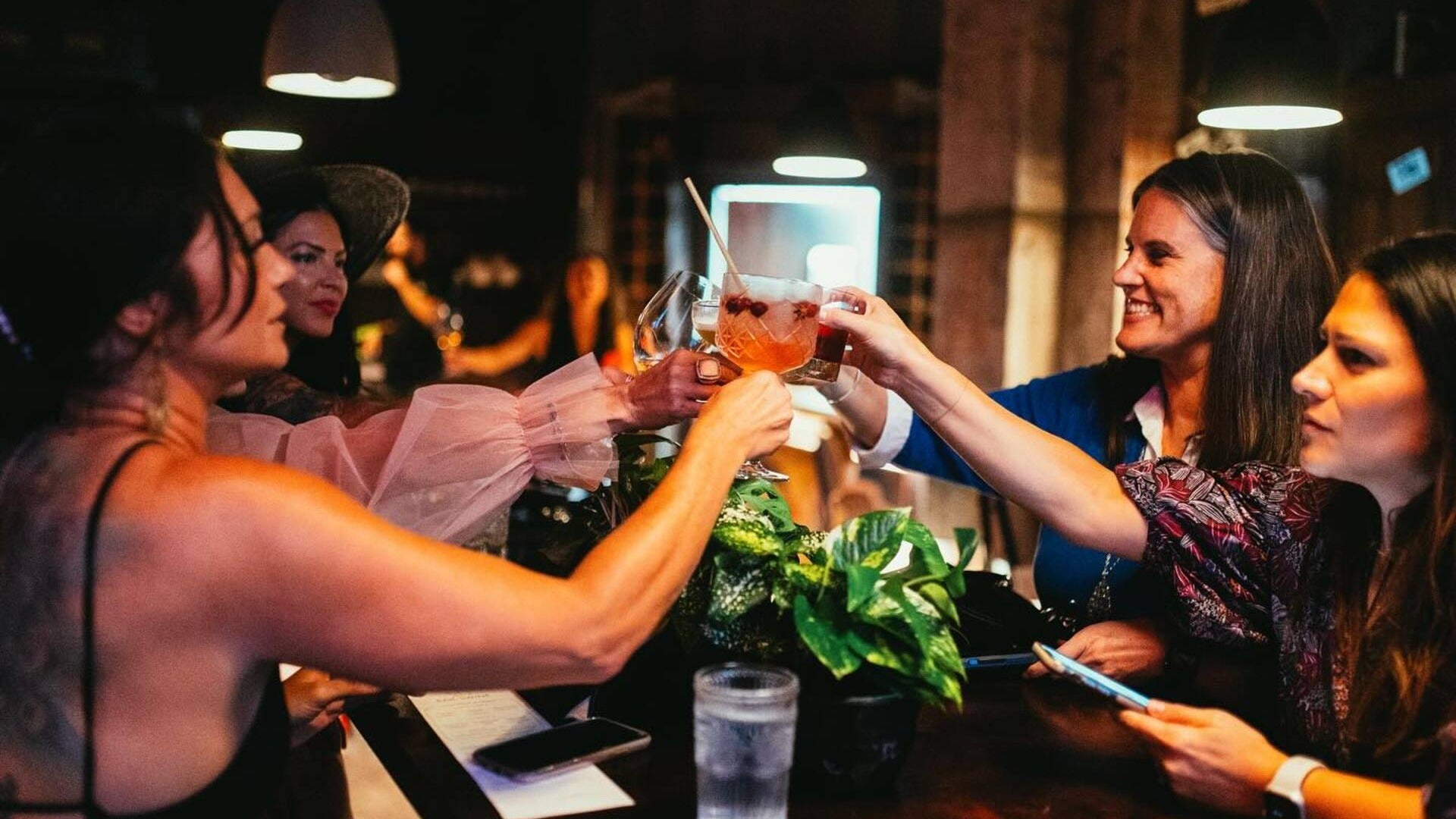 group of women toasting with alcohol in hand