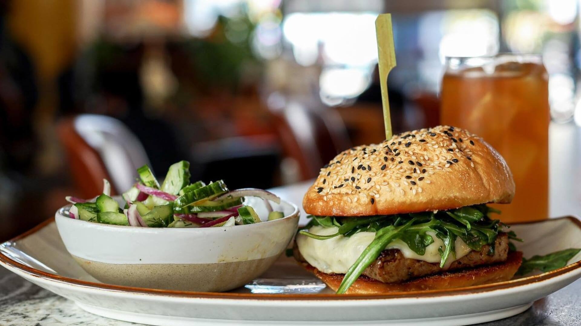 burger with a side of salad and iced tea at the back