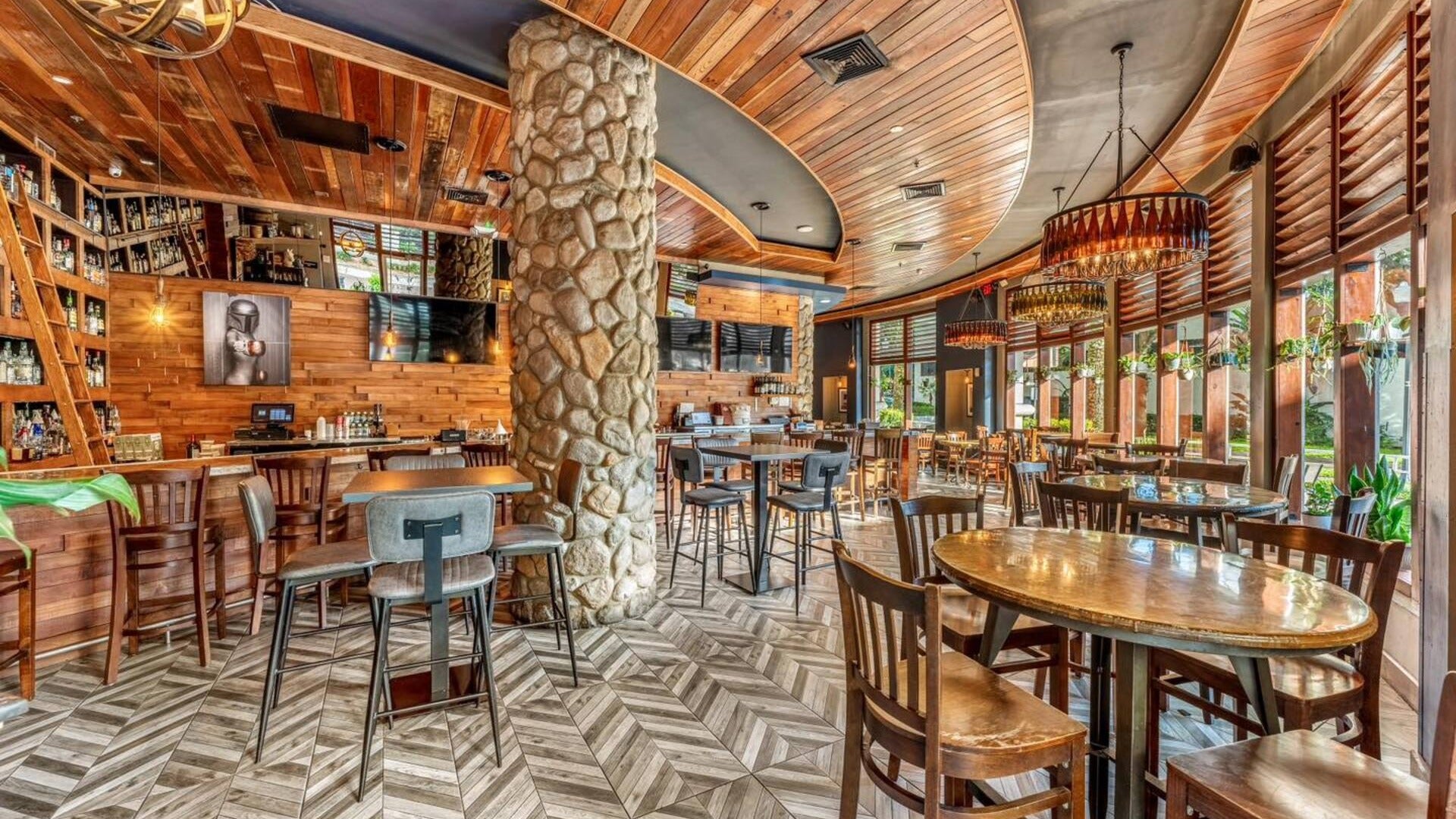 restaurant interior with tables and chairs, chandeliers, plants